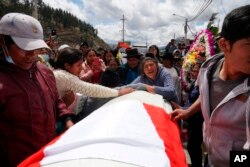 Parientes de Wilfredo Lizarme, de 18 años, quien murió en una protesta contra el gobierno, recorren las calles con el ataúd de los restos del joven en la ciudad de Andahuaylas, en el sur de Perú, el martes 13 de diciembre de 2022.
