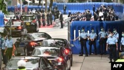 Guests drive past barriers near the Office for Safeguarding National Security of the Central People's Government in the Hong Kong Special Administrative Region after its official inauguration in Hong Kong on July 8, 2020. 