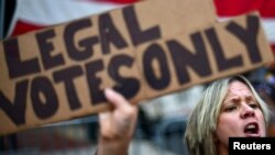 Una simpatizante del presidente Donald Trump porta un cartel que reza "solo votos legales" en desafío al conteo de votos de las elecciones presidenciales en Filadelfia, Pensilvania, el 8 de noviembre de 2020.