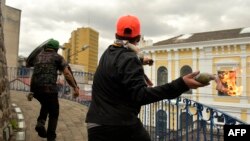 Manifestantes lanzan una bomba incendiaria casera al edificio de la Contraloría General de la nación en Quito, Ecuador, en el décimo día de protestas por un alza de precio a los combustibles decretada por el gobierno. Oct. 12 de 2019. AFP/Rodrigo Buendía.