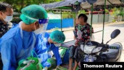 FILE PHOTO: Volunteers help a coronavirus disease (COVID-19) patient with extra oxygen in the town of Kale, Sagaing Region, Myanmar