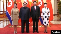 中國國家主席習近平和夫人彭麗媛在北京人大會堂同北韓國務委員會委員長金正恩和夫人李雪主合影。（2018年3月28日）