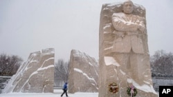 មនុស្ស​ម្នាក់ ដើរ​នៅ​ក្បែរ​ស្តូប​រំឭក​វិញ្ញាណក្ខន្ធ​លោក Martin Luther King, Jr. ខណៈ​ដែល​ព្យុះ​រដូវរងា​ បាន​បោកបក់​កាត់​តំបន់​រដ្ឋធានី​វ៉ាស៊ីនតោន កាលពី​ថ្ងៃ​អាទិត្យ ទី១៦ ខែ​មករា ឆ្នាំ២០២២។