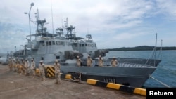 រូបឯកសារ៖ ទាហាន​ជើងទឹក​ឈរ​យាម​ល្បាត​នៅ​ក្បែរ​នាវា​ល្បាត​នៅ​មូលដ្ឋាន​កងទ័ព​ជើងទឹក​រាម​ក្នុង​ខេត្ត​ព្រះសីហនុ ថ្ងៃទី២៦ ខែកក្កដា ឆ្នាំ២០១៩។ រូប​ថត​នេះ​ត្រូវ​បាន​ថត​ពី​តាម​កញ្ចក់​បង្អួច។ (REUTERS/Samrang Pring)