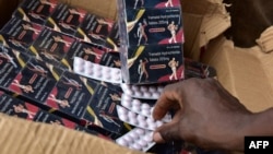 FILE - A policeman shows counterfeit medicine tablets during a police raid against shops selling fake medicine and counterfeit drugs on May 3, 2017 at the Adjame market in Abidjan. (AFP PHOTO / ISSOUF SANOGO)