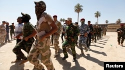 Shi'ite volunteers, who have joined the Iraqi army to fight against militants of the Islamic State, formerly known as the Islamic State in Iraq and the Levant (ISIL), march during training in Baghdad, July 9, 2014. 