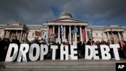 FILE - Protesters hold placards during a rally to show solidarity with Greece in front of Britain's National Gallery in central London, Feb. 15, 2015.