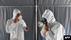 រូបឯកសារ៖ បុគ្គលិកសុខាភិបាលពាក់គ្រឿងប្រដាប់ការពារខ្លួន មុនពេលរៀបចំកន្លែងដាក់សាកសពនៅមន្ទីរពេទ្យ Saint Luc នៅក្រុង Namur កាលពីថ្ងៃទី២០ ខែមេសា ឆ្នាំ២០២០។ 