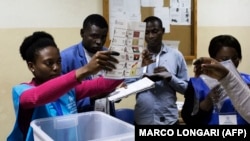 Uma delegada eleitoral mostra um boletim de voto durante a contagem no fim das eleições gerais em Luanda, Angola. 13 de Agosto 2017