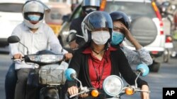 FILE - Cambodians wear masks to avoid the contact of coronavirus in Phnom Penh, Cambodia, Tuesday, Jan. 28, 2020. (AP Photo/Heng Sinith