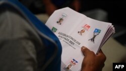 Funcionarios electorales cuentan las papeletas después del cierre de los colegios electorales durante los comicios parlamentarios y locales, en San Salvador, el 28 de febrero de 2021.