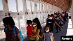 Migrantes centroamericanos previamente expulsados de EE. UU. cruzan de nuevo el puente frontrizo hacia El Paso, Texas, para continuar su solicitud de asilo el 15 de junio de 2021.