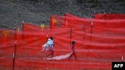 Niños inmigrantes esperan ser procesados en un centro de tránsito de la Patrulla Fronteriza de EE. UU. después de cruzar la frontera desde México en Eagle Pass, Texas, el 22 de diciembre de 2023.