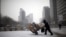 FILE - A man carries scraps in a handcart during snowfall in central Seoul, South Korea, Feb. 16, 2016. With the recycling market dimming, Seoul is turning to upcycling to reduce waste.