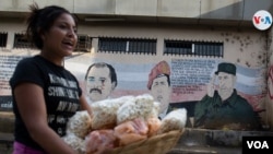 Archivo. Una comerciante pasa por una calle de Managua. Foto Houston Castillo, VOA