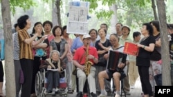 一組退休人員在北京公園裡唱紅歌。