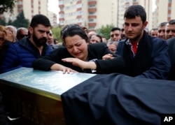 A relative cries over the coffin of Uygar Coskun, 32, killed in Saturday's bombing attacks, during his funeral, in Ankara, Turkey, Oct. 12, 2015.