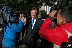 Paul Manafort makes his way through television cameras as he walks from Federal District Court in Washington, Oct. 30, 2017.