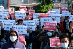 Protesters hold posters in support of the National Unity Government (NUG) during a demonstration against the military coup on "Global Myanmar Spring Revolution Day" in Taunggyi, Shan state on May 2, 2021. (Photo by STR / AFP)