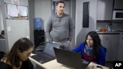 En esta imagen, tomada el 16 de octubre de 2018, César Batiz, director de El Pitazo (centro), junto a dos periodistas en la redacción de la popular plataforma digital en Caracas, Venezuela.