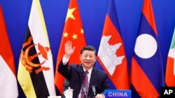 In this photo released by Xinhua News Agency, Chinese President Xi Jinping waves as he chairs the ASEAN-China Special Summit to commemorate the 30th Anniversary of ASEAN-China Dialogue Relations via video link from Beijing, China on Monday, Nov. 22, 2021.