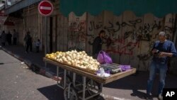 Palestinski prodavac sa tezgom ispred zatvorene prodavnice u Ramali na Zapadnoj obali. 2. maj, 2023. (Foto: AP/Nasser Nasser)
