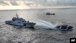 2024年12月4日，菲律賓指控中國海警船（左）在有爭議的斯卡伯勒淺灘附近海域向菲律賓船隻發射水砲。 (西菲律賓海國家特遣部隊提供）