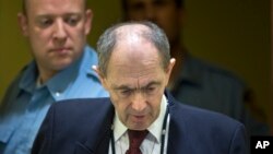 FILE - In this Wednesday April 8, 2015 file photo, Zdravko Tolimir, a Bosnian Serb general convicted of genocide in the 1995 Srebrenica massacre, is escorted by U.N. security guards as he arrives in the courtroom of the the Yugoslav war crimes tribunal who delivered its judgment in his appeal case in The Hague, Netherlands.