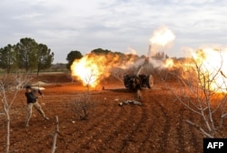 An opposition fighter fires a gun from a village near al-Tamanah during ongoing battles with government forces in Syria's Idlib province on Jan. 11, 2018.