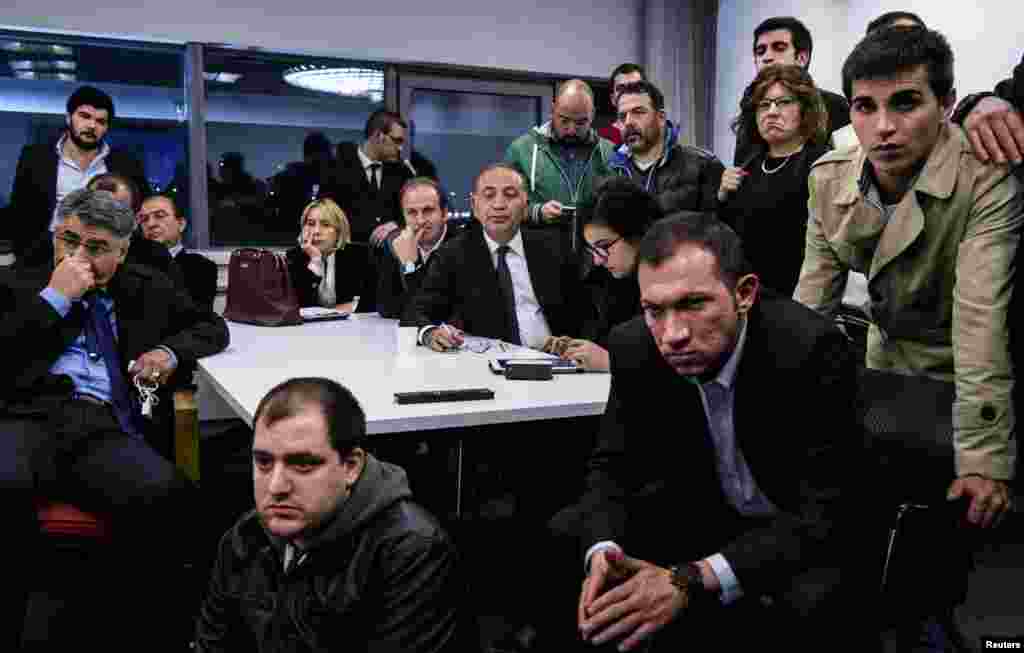 Gursel Tekin (center), main opposition Republican People's Party (CHP) deputy chairman, watches election results on TV with party members at CHP headquarters in Ankara, March 30, 2014.