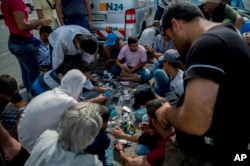FILE - Migrants charge their mobile phones at the border station between Serbia and Hungary near Horgos, Serbia, Wednesday, Sept. 16, 2015.