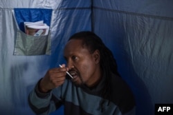 45-year-old Oscar Tyumre uses an HIV self-testing kit, administered by students from the University of the Witwatersrand in Hillbrow, Johannesburg, on March 19, 2018.