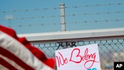 បាតុករ​ម្នាក់​លើក​ស្លាកសញ្ញា​នៅ​ខាងក្រៅ​ក្លោង​ទ្វារមន្ទិរ Port of Entry កាលពី​ថ្ងៃទី​២១ មិថុនា ឆ្នាំ ២០១៨ក្នុង​ទីក្រុង​ Fabens រដ្ឋ​តិចសាស​។