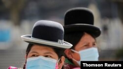 Mujeres indígenas aymaras con máscaras protectoras en la Plaza Murillo durante una celebración por el 195 aniversario de la fundación de Bolivia en el palacio presidencial, en La Paz, Bolivia, el 6 de agosto de 2020.