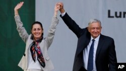 ARCHIVO - El presidente de México, Andrés Manuel López Obrador y la entonces alcaldesa Claudia Sheinbaum, saludan a sus simpatizantes en un acto de campaña en el Zócalo, la principal plaza de Ciudad de México, el 1 de julio de 2019. Sheinbaum es favorita para sustituirle.