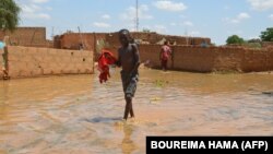 Un enfant patauge dans l'eau dans une rue inondée du quartier de Kirkissoye à Niamey, le 3 septembre 2019. 