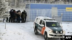 ជនចំណាកស្រុក និងរថយន្តរបស់ឆ្មាំព្រំដែនហ្វាំងឡង់ត្រូវបានគេឃើញនៅឯច្រកអន្តរជាតិនៅ Salla ភាគខាងជើងប្រទេសហ្វាំងឡង់នៅថ្ងៃទី២២ ខែវិច្ឆិកាឆ្នាំ២០២៣ ។