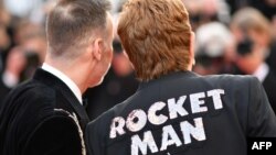 El cantante y compositor británico Elton John (d) y su esposo, el cineasta canadiense David Furnish, llegan a la proyección de la película 'Rocketman' en la 72a edición del Festival de Cine de Cannes , Francia, el 16 de mayo de 2019. (foto de Alberto PIZZOLI / AFP).
