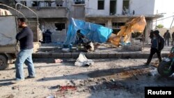 Residents inspect the damage as blood stains are seen on the ground after airstrikes by pro-Syrian government forces in the rebel-held al-Sakhour neighborhood of Aleppo, Syria, Feb. 8, 2016. (REUTERS/Abdalrhman Ismail)