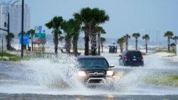 Cars drive through flood waters along route 90 as outer bands of Hurricane Ida arrive Sunday, Aug. 29, 2021, in Gulfport, Miss. (AP Photo/Steve Helber)
