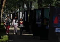 Peatones, uno de ellos emboazado con una máscara facial, caminaban el martes por una calle casi vacía del Paseo de la Reforma en la Ciudad de México.