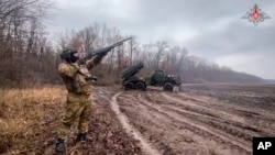 俄罗斯国防部2025年1月16日发布的照片显示，一名俄罗斯士兵在乌克兰一个未披露的地点保护“格勒”自行多管火箭发射器的阵地不受无人机袭击。