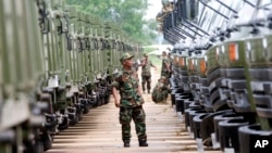 FILE PHOTO - A Cambodian army soldier looks at Chinese military vehicles displayed before a handover ceremony at a military airbase in Phnom Penh, Cambodia, Wednesday, June 23, 2010. 