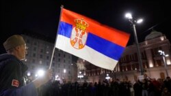 Një burrë mban një flamur serb gjatë një proteste në Beograd, Serbi (28 nëntor 2021)