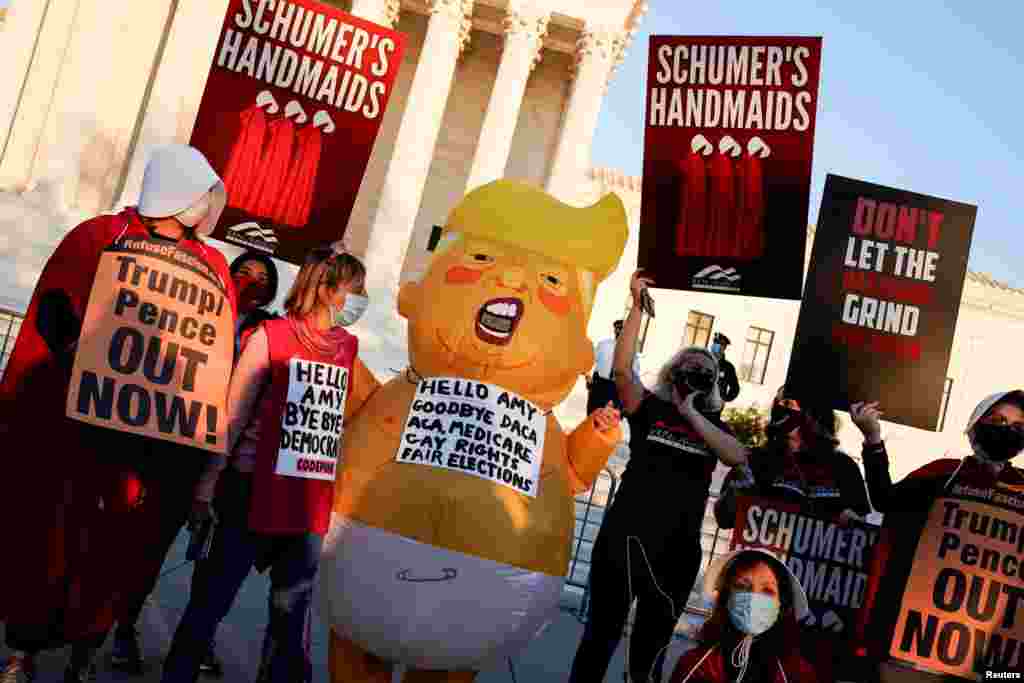 Activistas que se oponen a la elección de Barrett muestran pancartas que piden sacar al presidente Trump del poder e insultan al líder de la mayoría del Senado, Mitch McConnell, el lunes 26 de octubre de 2020.