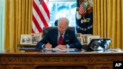 拜登總統在白宮橢圓形辦公室簽署一系列有關醫保的行政令（2021年1月28日）