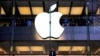 Seorang pelanggan berdiri di bawah logo Apple yang menyala saat dia melihat ke luar jendela toko Apple yang terletak di pusat kota Sydney. (Foto: Reuters)