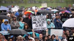 FILE - A person holds a sign that reads "Fund Climate Change Research - Saving the Planet Is Not a Waste of Money" during the March for Science in Washington, April 22, 2017.