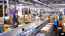 Cette image tirée d'une vidéo montre des personnes travaillant dans l'entrepôt de l'UNICEF, le plus grand entrepôt d'aide humanitaire au monde, à Copenhague, au Danemark, le mardi 13 octobre 2020. 