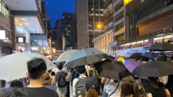 參與中環流水式遊行人士佔據馬路，高舉雨傘，導致交通受阻，但是沒有搗路及衝擊警方，遊行過程大致和平 (攝影：美國之音湯惠芸）